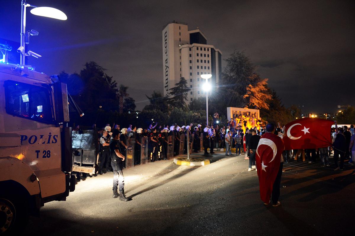 Turkiska nationalister och polisen står öga mot öga utanför Hürriyets redaktion i Istanbul.