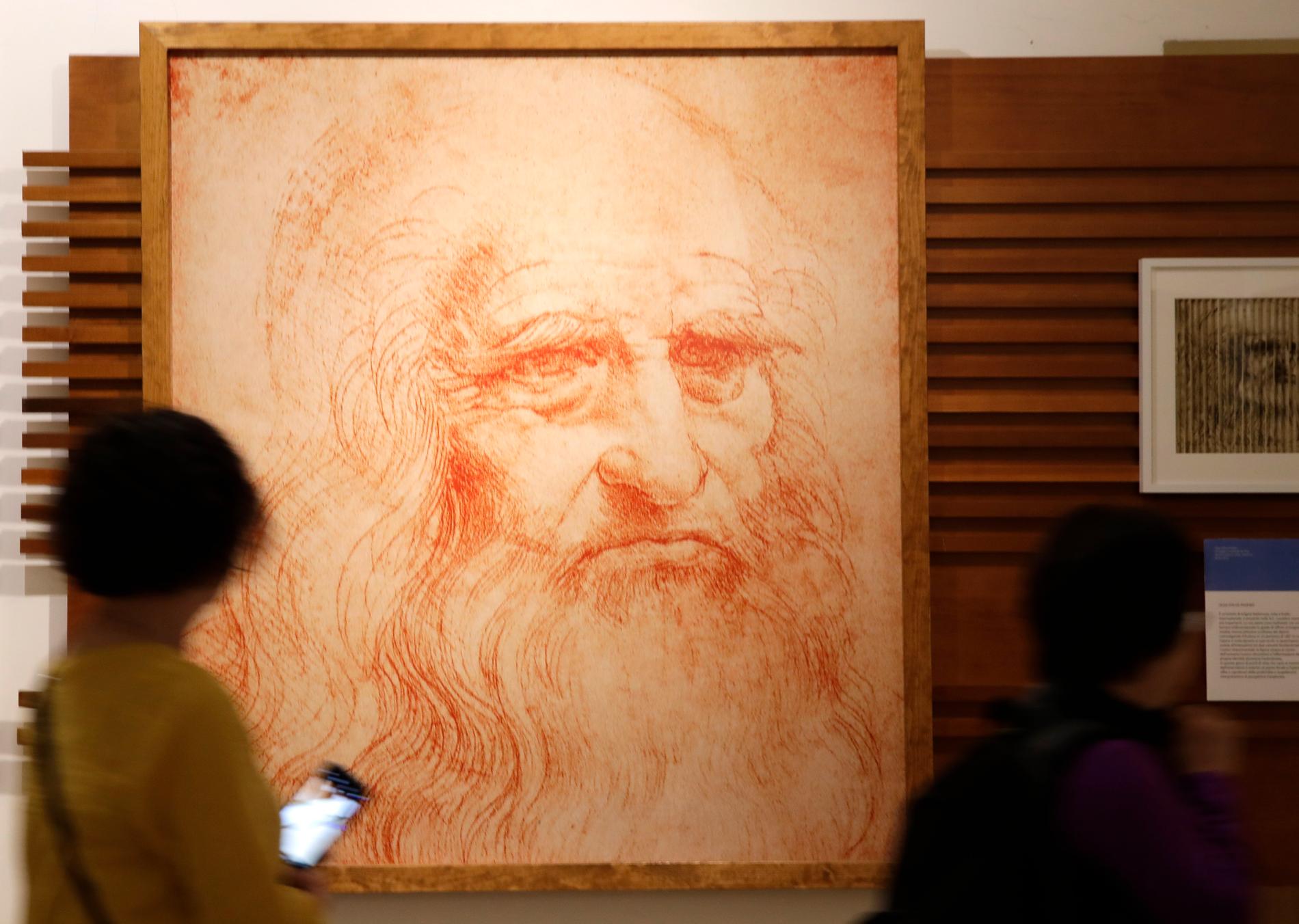 Besökare tittar på ett porträtt av renässanskonstnären Leonardo da Vinci (1452–1519) på en utställning. Arkivbild.