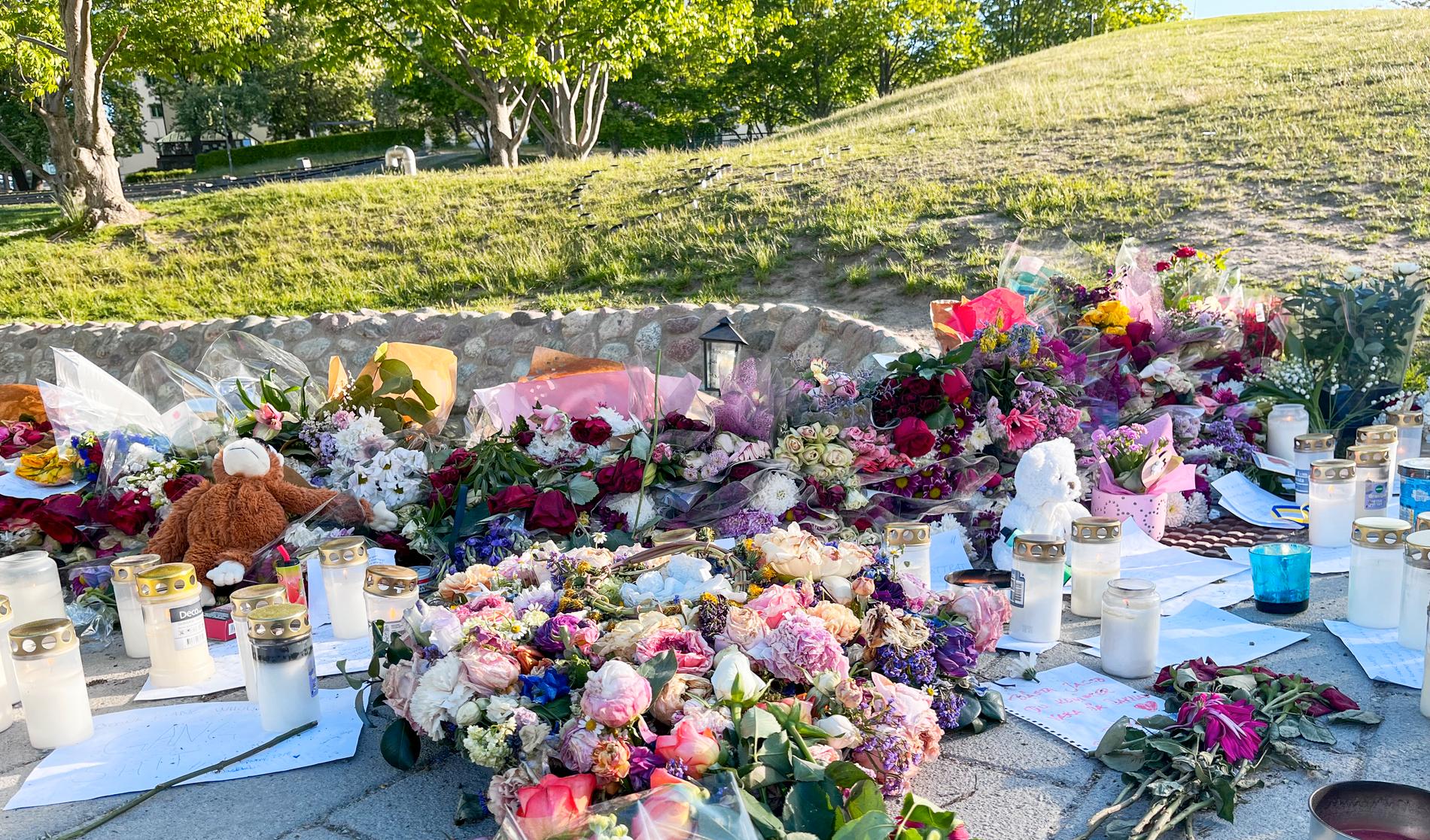 Blommor och ljus på platsen där en 15-årig pojke höggs till döds under ett bråk i Lumaparken i Hammarby sjöstad i södra Stockholm. Arkivbild.