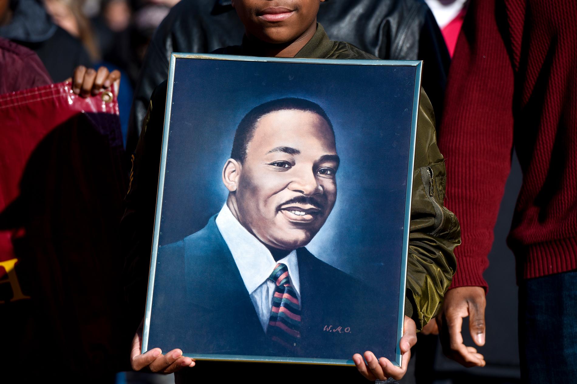 Ett porträtt av människorättskämpen Martin Luther King, som mördades för drygt 50 år sedan i USA, hålls upp vid en manifestation i Texas.