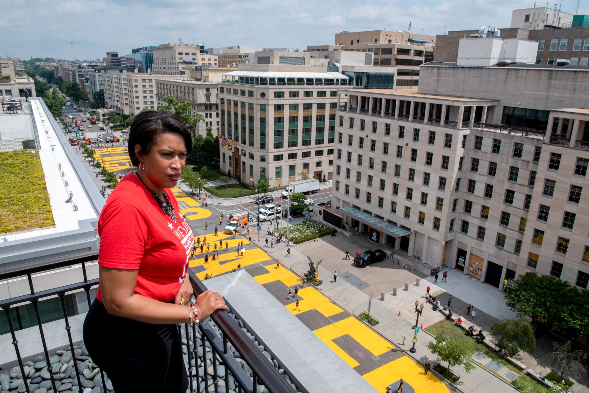 Borgmästaren i Washington  DC Muriel Bowser tittar ut över den jättelika målning på gatan som leder fram mot Vita huset med orden Black Lives Matter målade i gult.