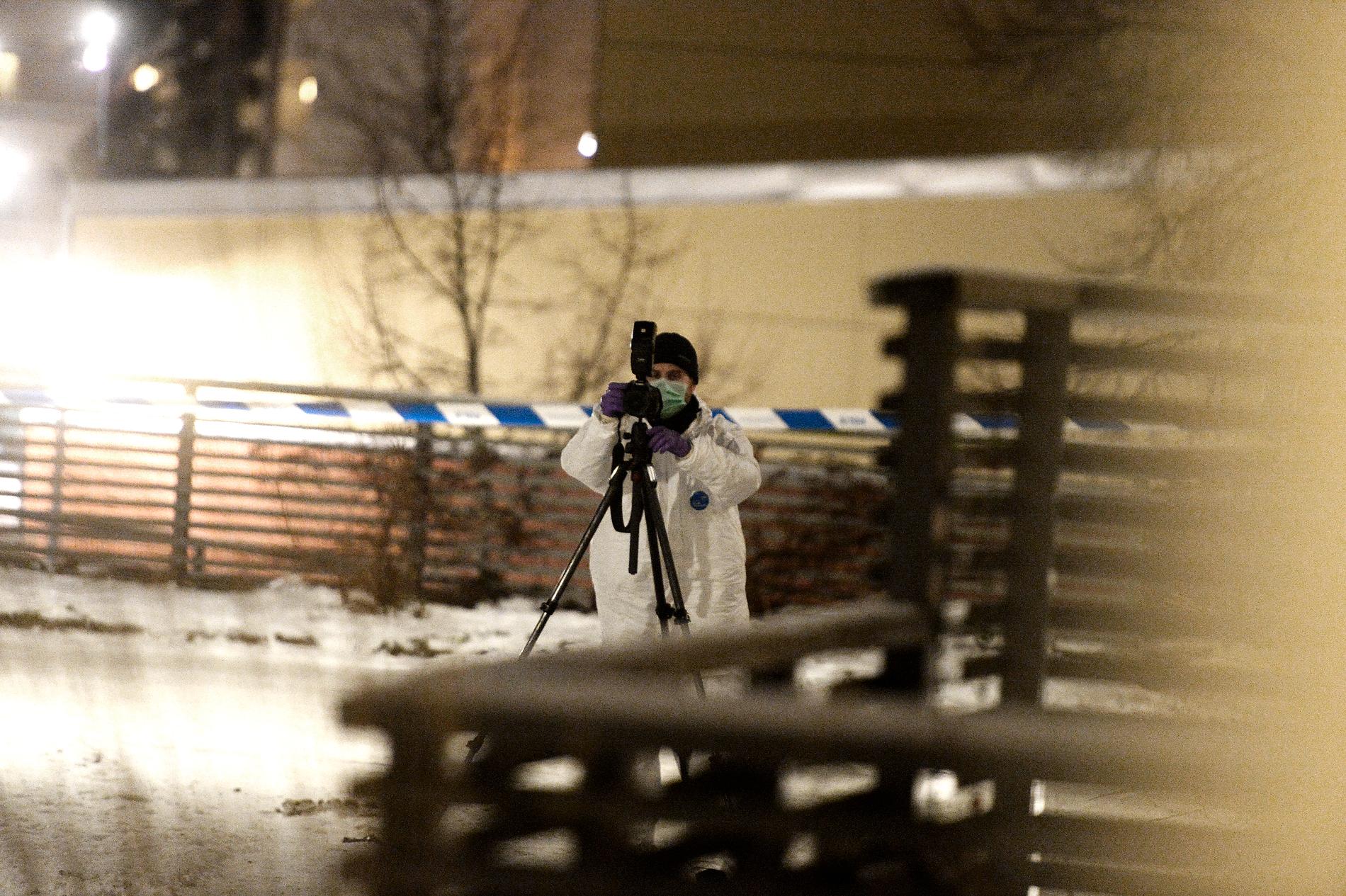 En polistekniker fotograferar brottsplatsen.