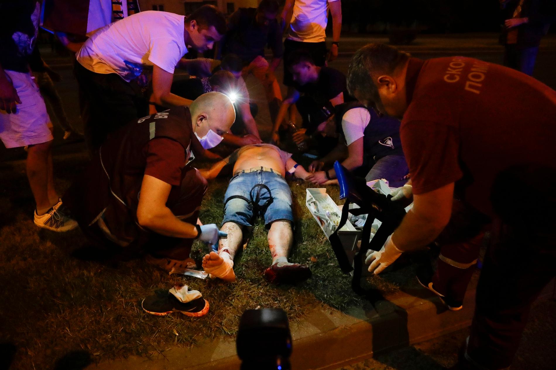 En skadad man får vård under protesterna i huvudstaden Minsk.