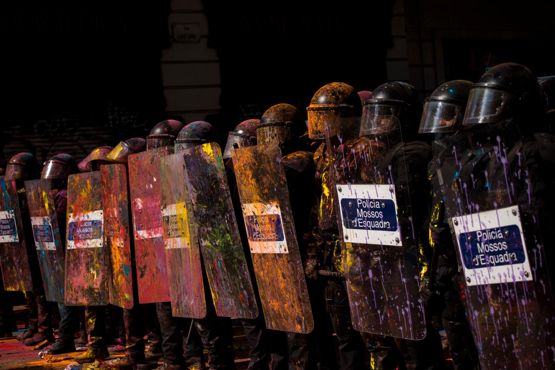 Demonstranter i Barcelona har sprutat färg på de kravallutrustade poliserna.