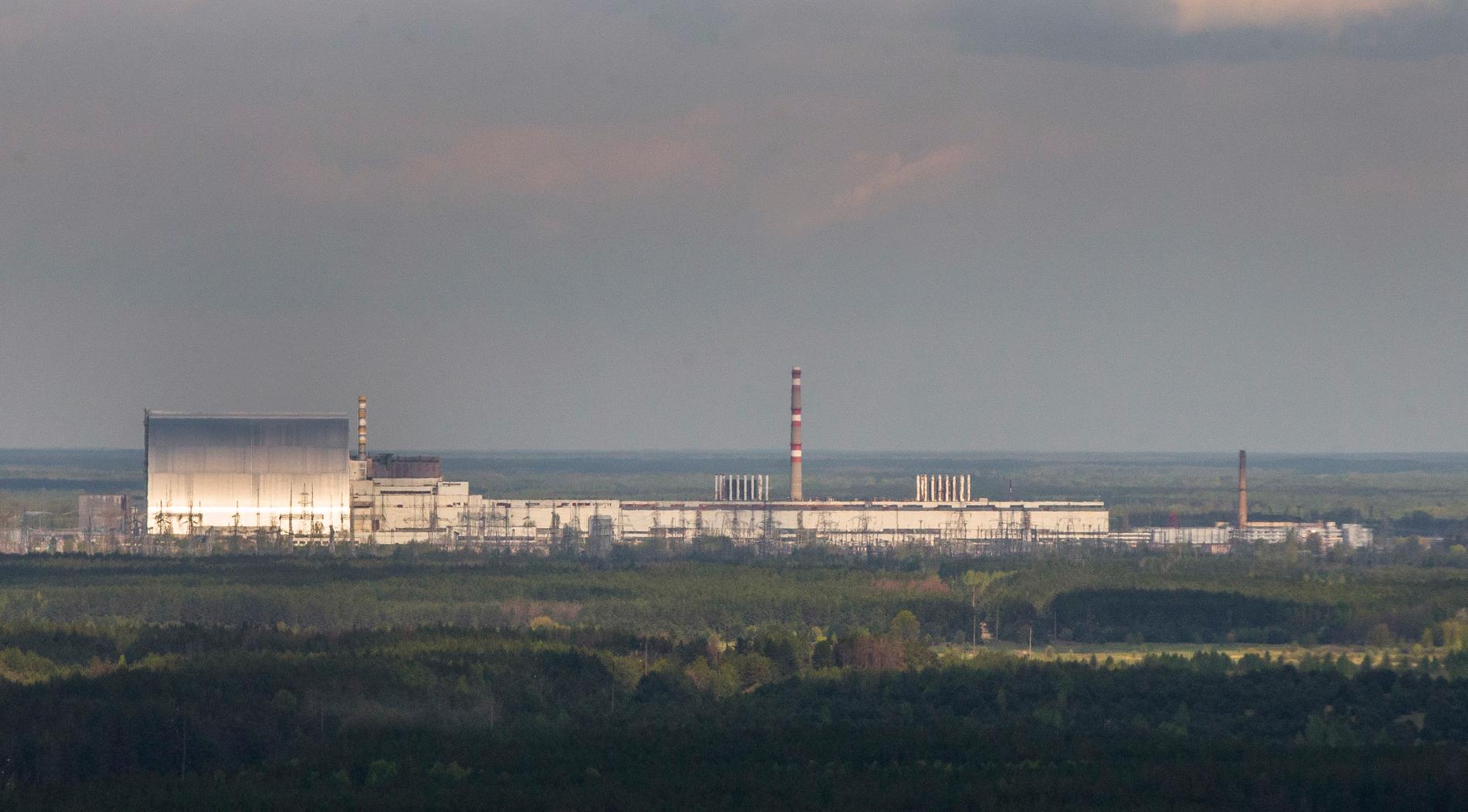 Kärnkraftverket i Tjernobyl. Till vänster den nya stålsarkofagen som är byggd över reaktorn som exploderade 1986. Bild från i våras, på årsdagen av olyckan.