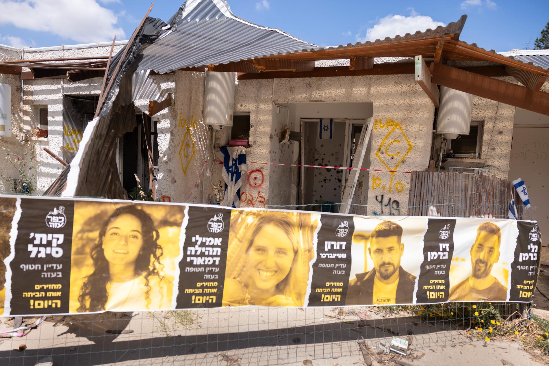 Framför husen hänger bilder på de som dödats och kidnappats.