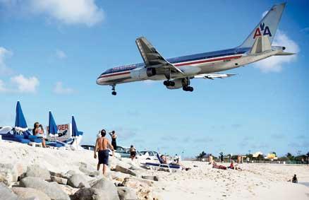 När man badar på stranden Maho Bay i Philipsburg gäller det att huka sig – här snuddar charterplanen vid palmtopparna på inflygningen till öns enda flygplats.