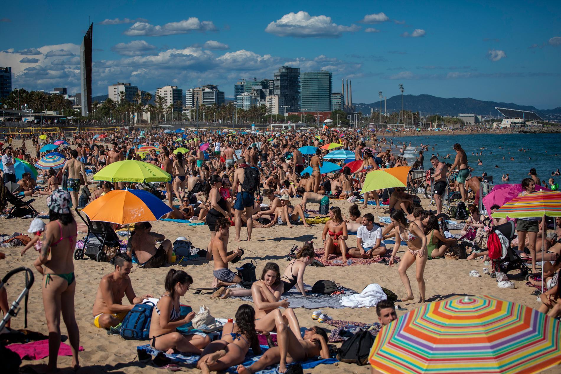 I Barcelona är stränderna redan fullpackade, men turistindustrin skriker efter gäster. Bild från i lördags.