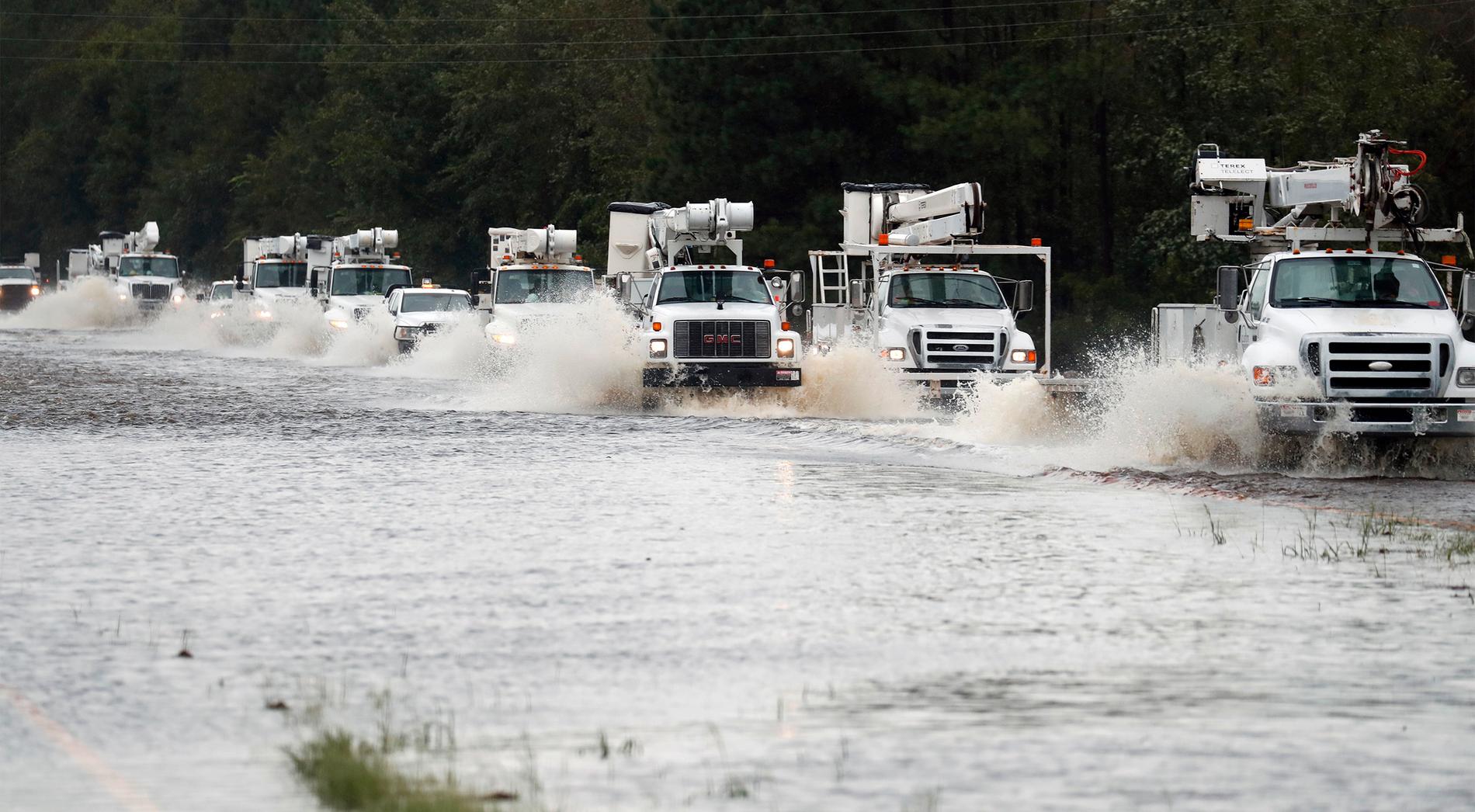 Hjälplastbilar färdas på den för allmänheten avstängda Highway 70 i North Carolina på lördagen.