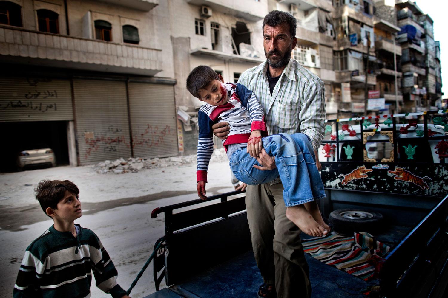 Sexårige Mustafa bärs in på sjukhuset av sin far. Mustafa var ute och lekte med sin kusin när han träffades av splitter från en granat.