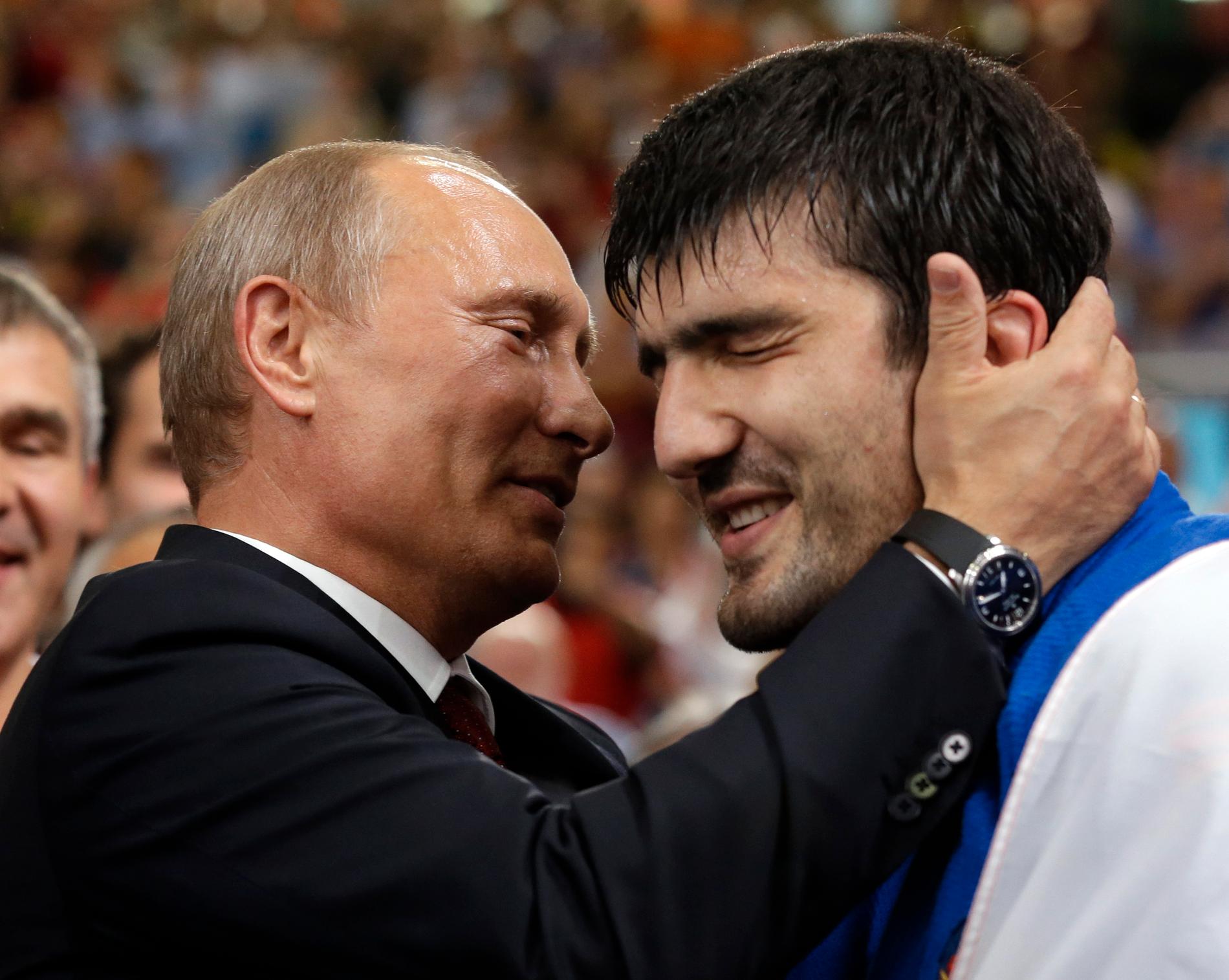 Vladimir Putin kramar om en rysk guldmedaljör i OS.