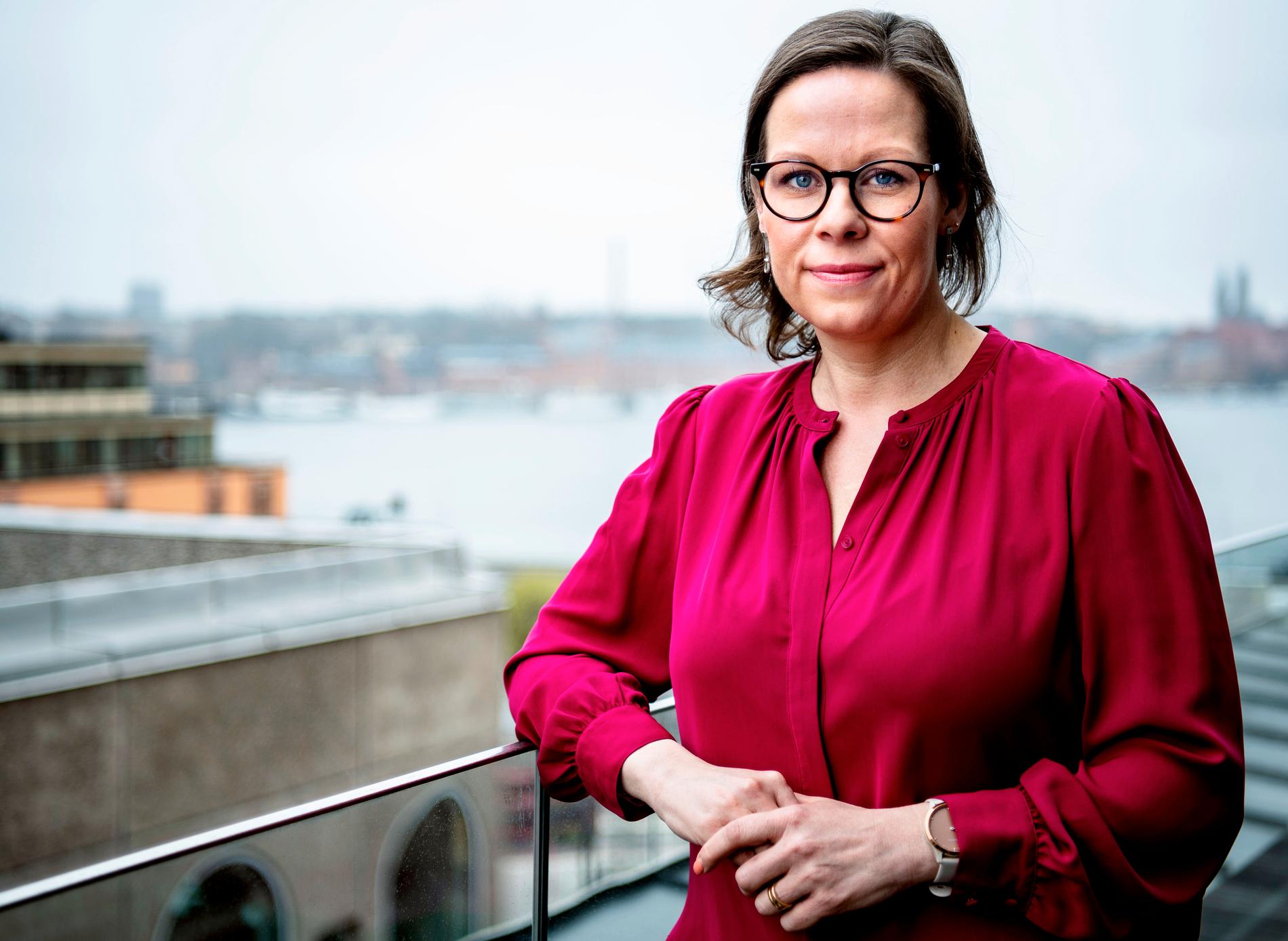 Ministern på balkongen i regeringsbyggnaden, med utsikt över riddarfjärden. Hennes uppdrag är att få färre asylsökande att komma hit – och få fler att återvända hem. 