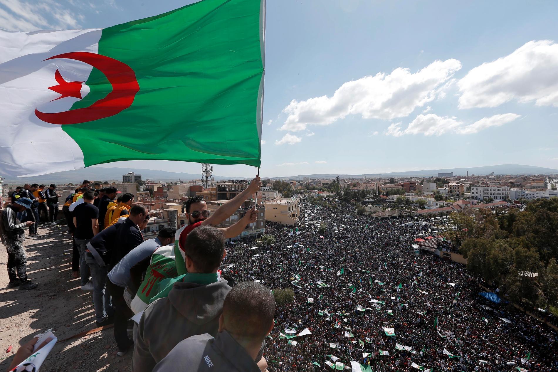 En demonstrant håller i en algerisk flagga i Bordj Bou Arreridj, sydöst om Alger, under fredagens omfattande protester i Algeriet.