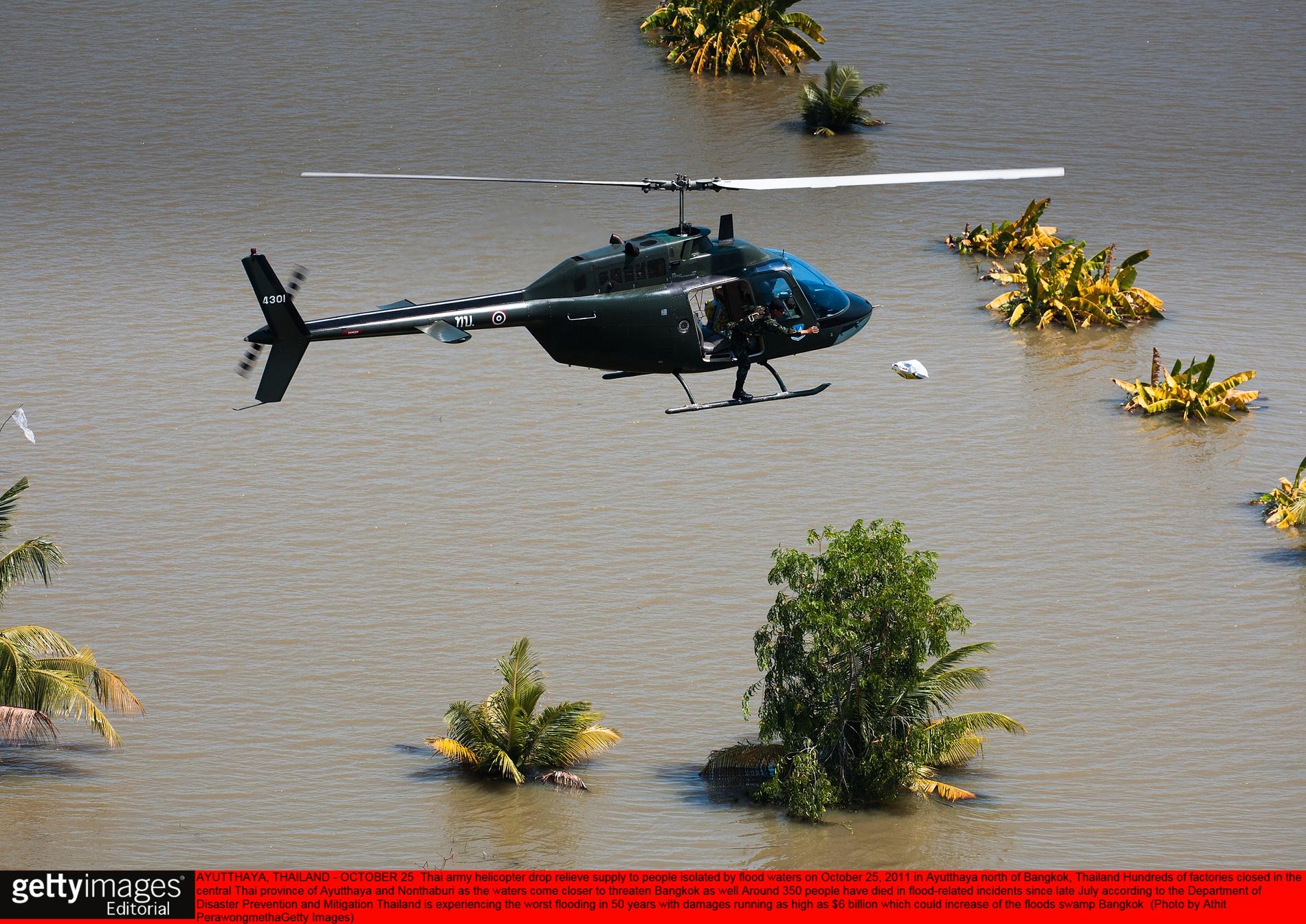 En helikopter levererar matpaket till människor i översvämningsområden.