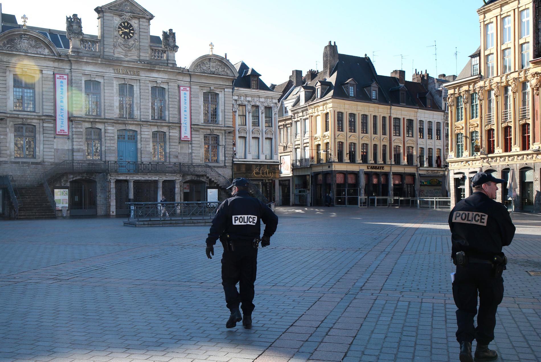 Polis patrullerar ett tomt torg i Lille i norra Frankrike.