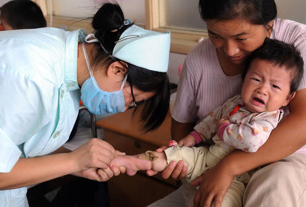 Får vård Alla barn som har insjuknat av den farliga mjölkersättningen får gratis vård. Här får ett kinesiskt barn behandling av sjukvårdspersonal.