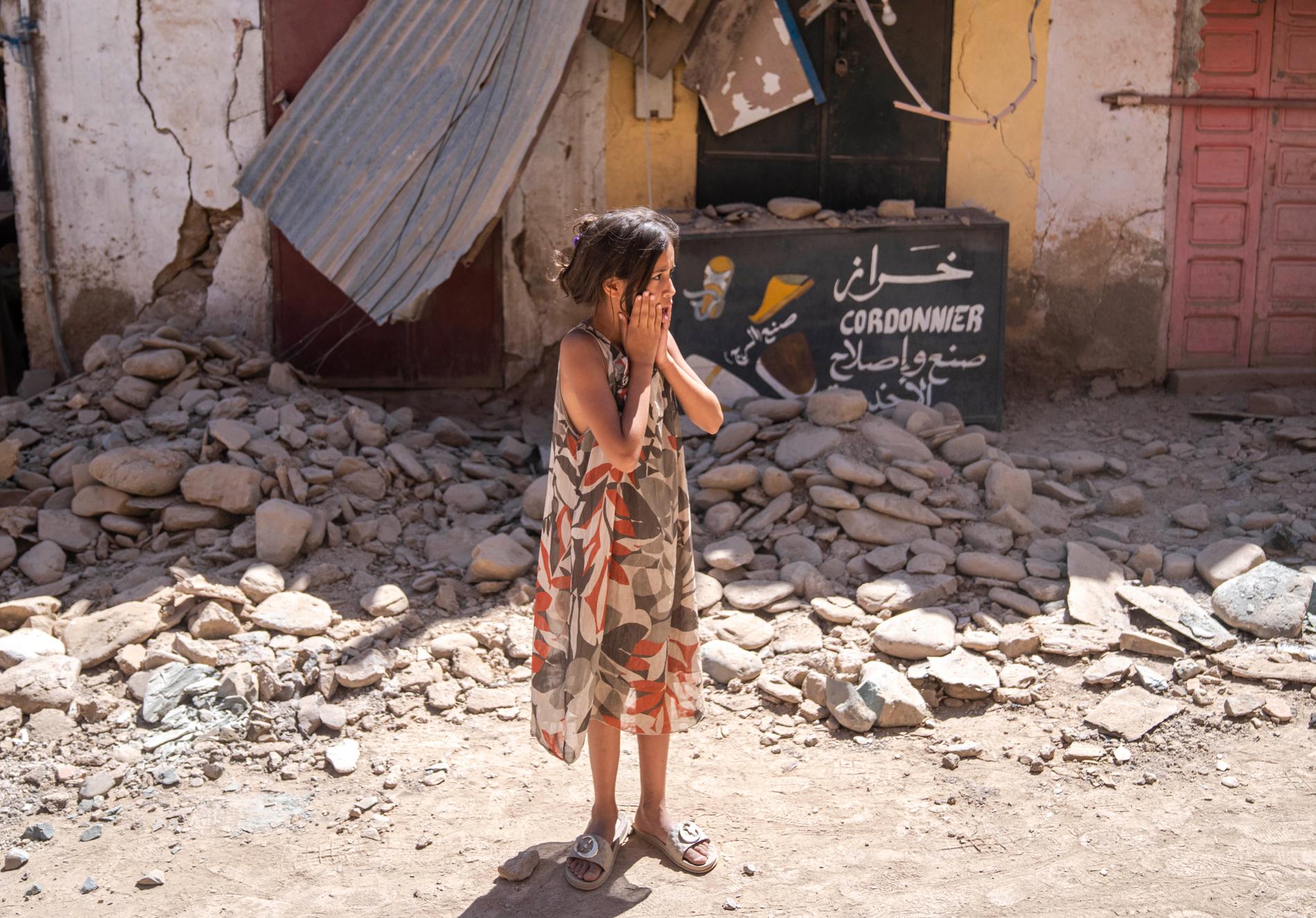 En flicka ser ut över rasmassorna i staden Amizmiz.