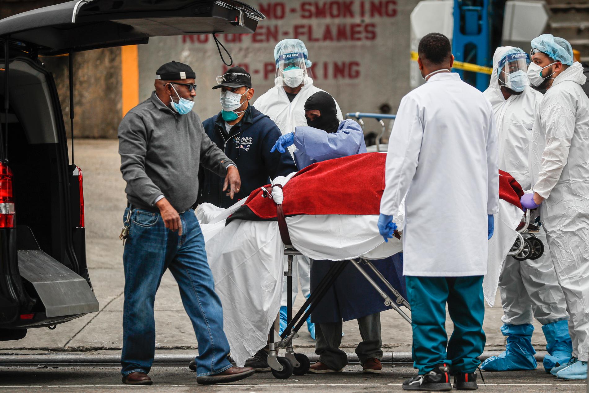 Sjukvårdspersonal hjälper till att transportera bort en person som dött av coronaviruset i New York. 
