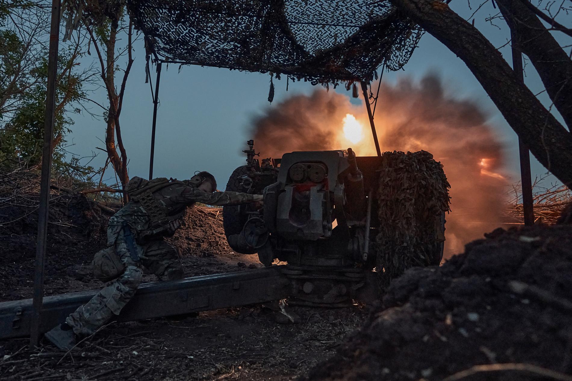 En soldat från ukrainska 10:e Assault Brigade Edelweiss avfyrar en D-30-kanon mot ryska positioner vid frontlinjen nära Bakhmut. Bilden är från i juli i år. 