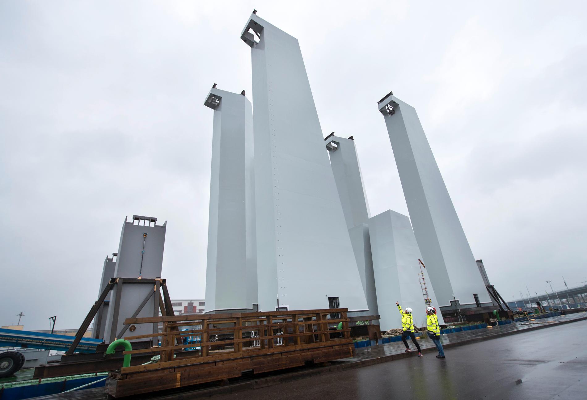 Pylonerna till Hisingsbron står på en pråm i Frihamnen i väntan på att bogseras till broplatsen.