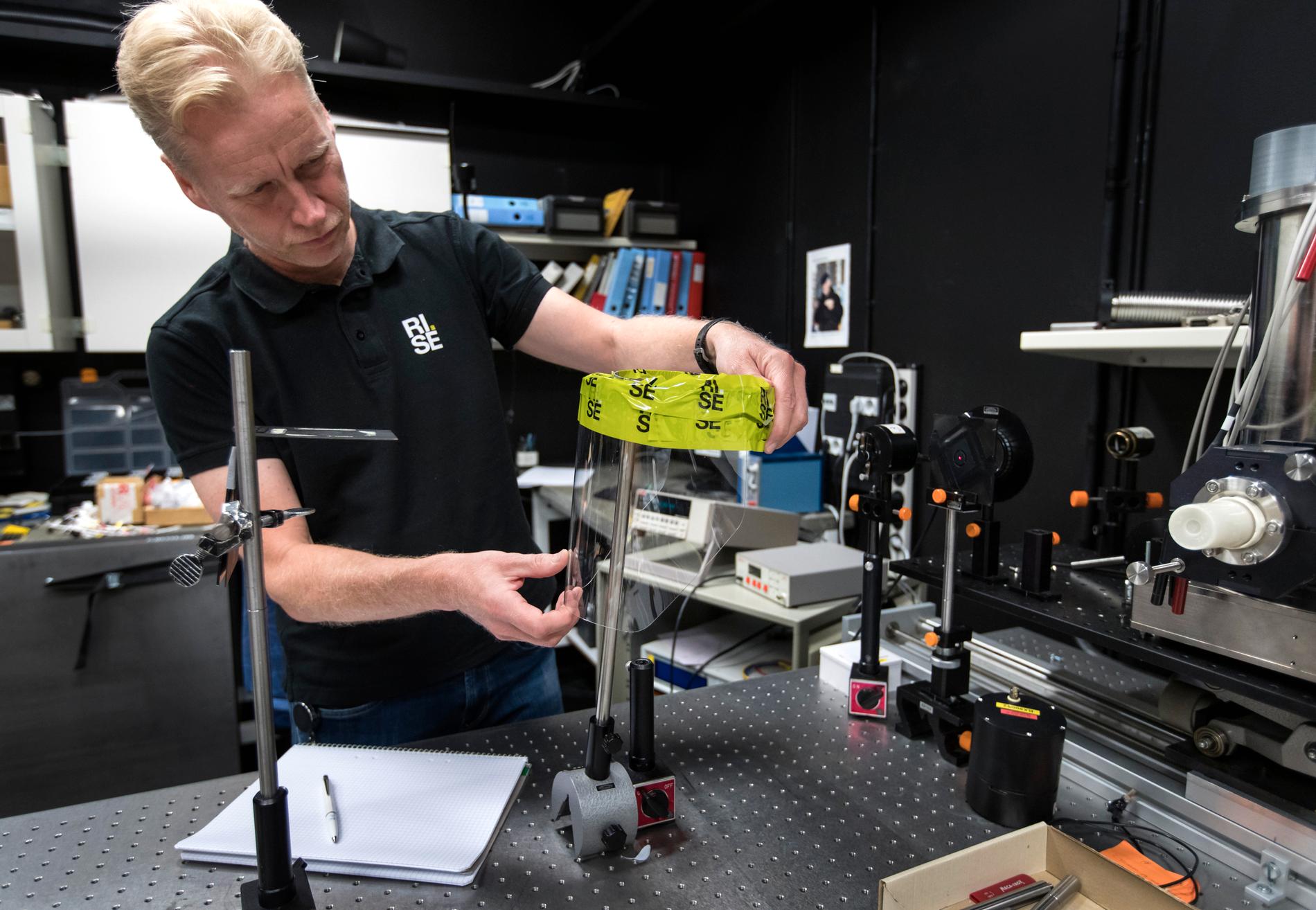 Per Olof Hedekvist på forskningsinstitutet Rise i Borås testar ett skyddsvisir med laser för att se hur väl det fungerar.