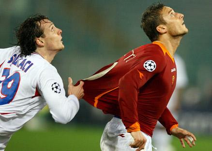 Sebastien Squillaci försöker få stopp på Totti med ojusta medel.