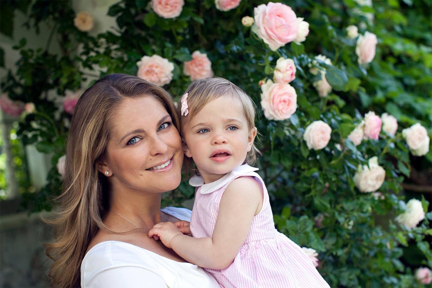 Även Leonore, 1, har fotograferats i sin mammas famn, iklädd en rosa klänning och rosett.
