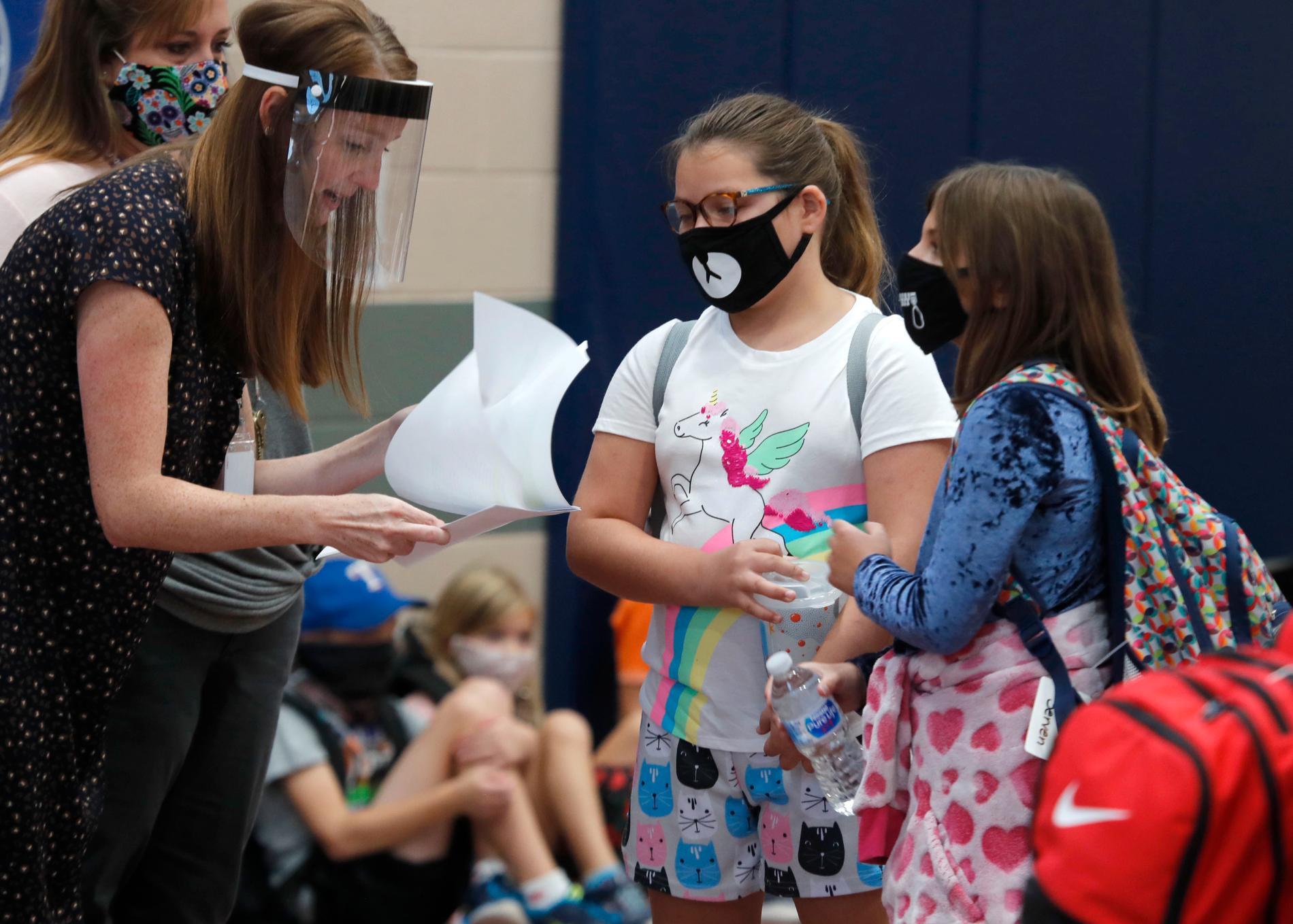 Elever och lärare med munskydd respektive visir vid en skola i Texas som öppnade förra veckan.