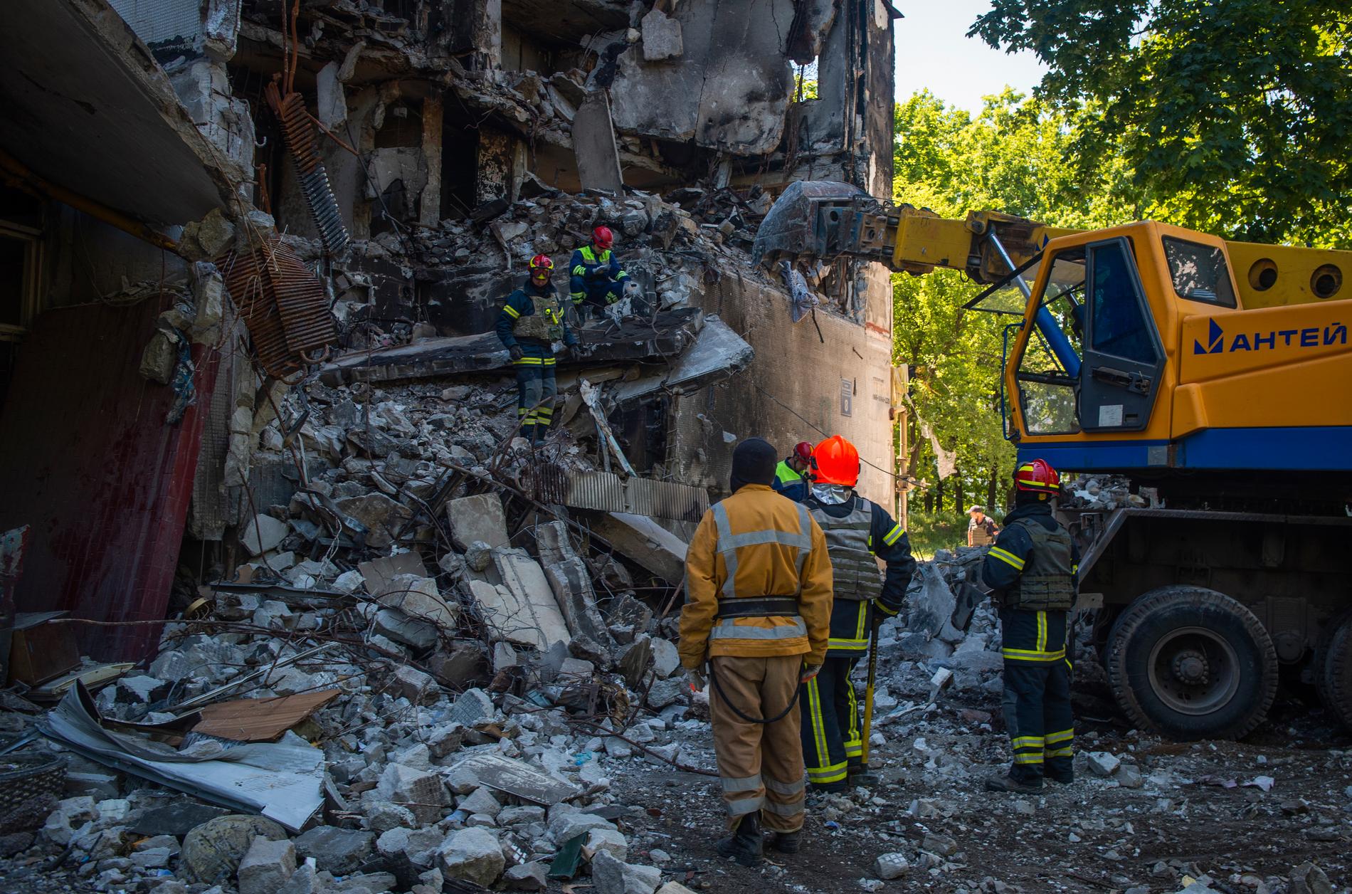 Räddningspersonal vid en skadad byggnad i Charkiv i en bild från den 4 juni.