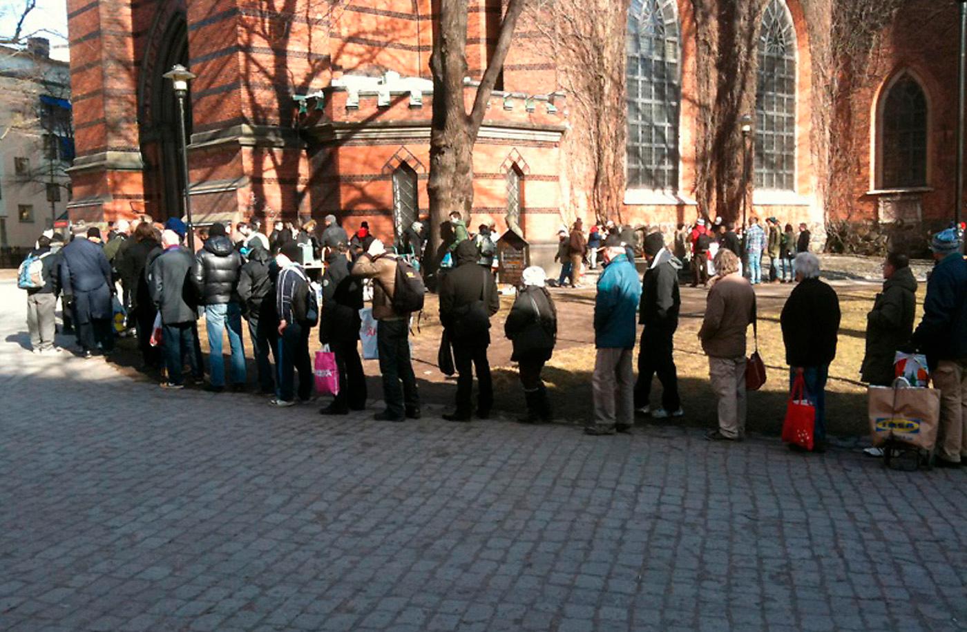 människor i kö Bilden på köande människor vid soppköket utanför St:a Clara kyrka i Stockholm sprids som en löpeld på nätet.