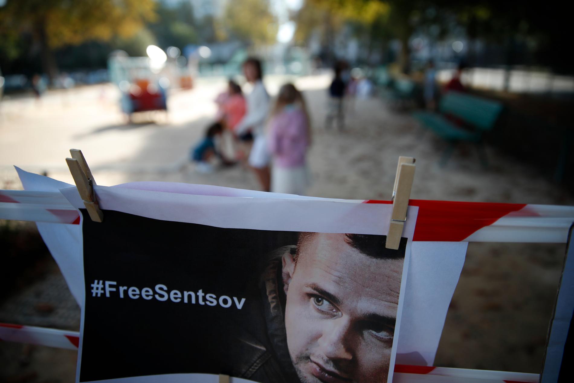 Ett foto på den tidigare hungerstrejkande ukrainska filmregissören Oleg Sentsov som sitter i fängelse i Ryssland. Bilden är från en protest framför ryska ambassaden i Paris tidigare i år. Arkivbild.