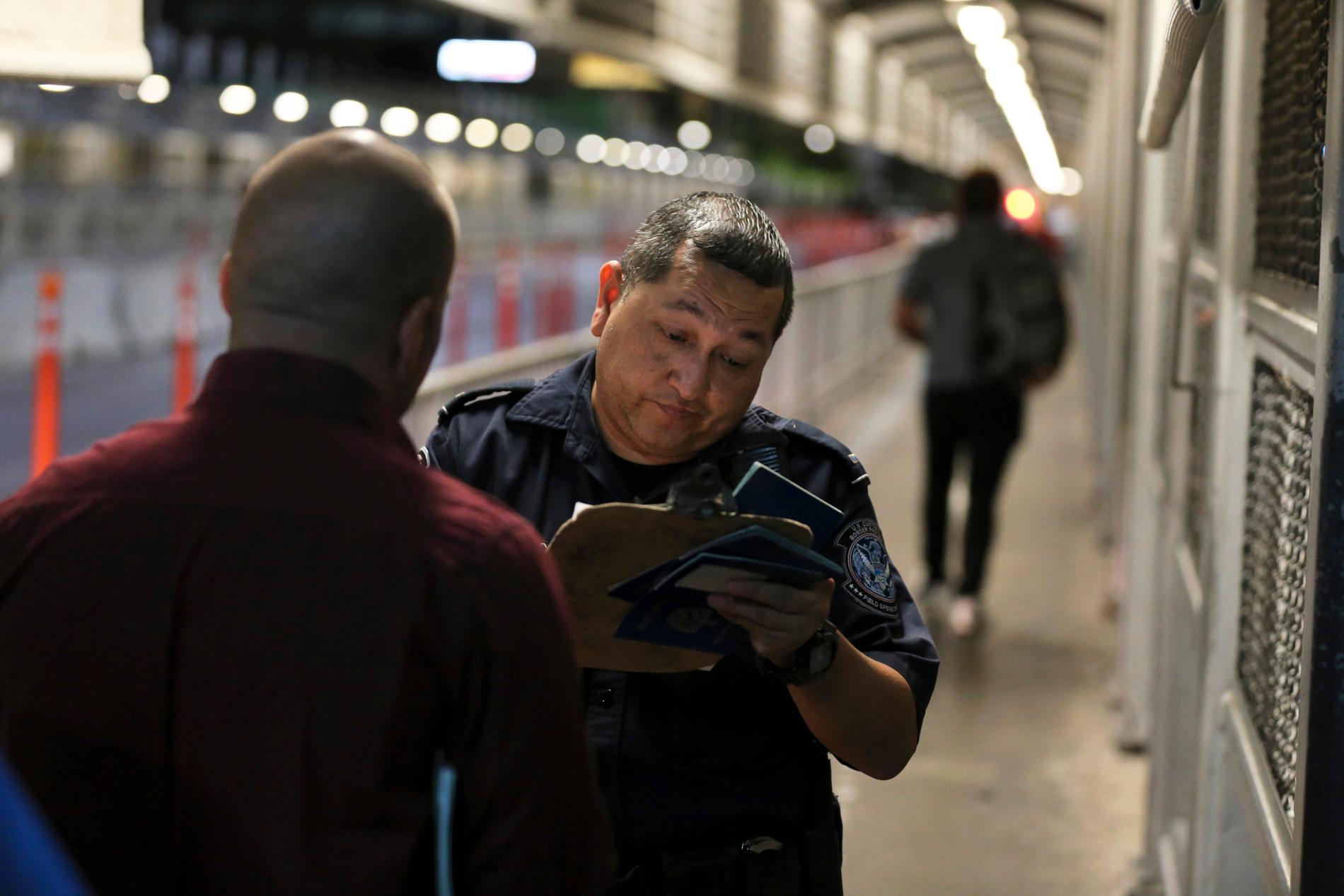 En amerikansk gränsvakt kontrollerar en migrants id-handlingar. Arkivbild.