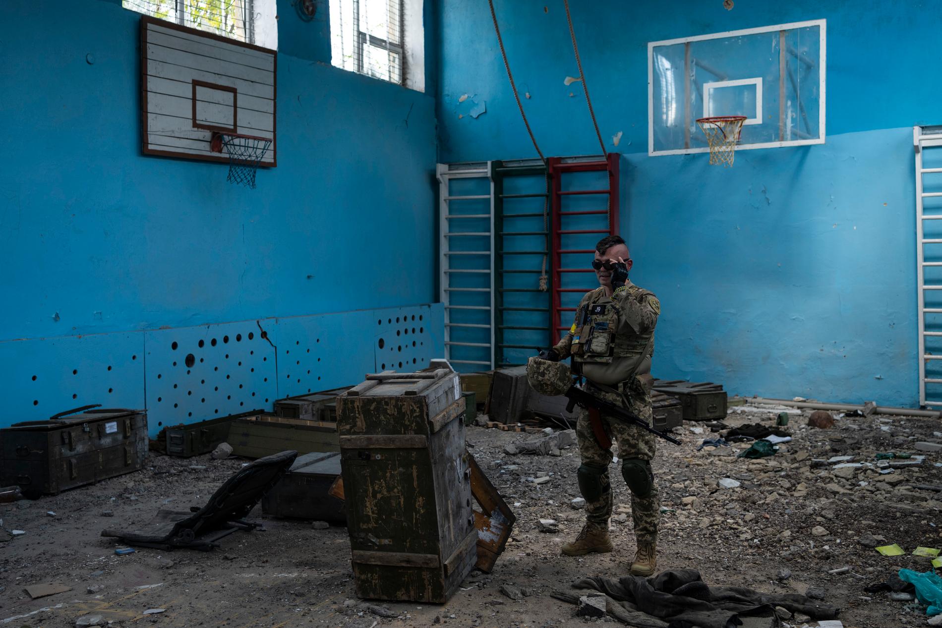 En ukrainsk soldat inspekterar en förstörd idrottshall i en skola i Vilchivka i utkanten av storstaden Charkiv i östra Ukraina, den 20 maj.
