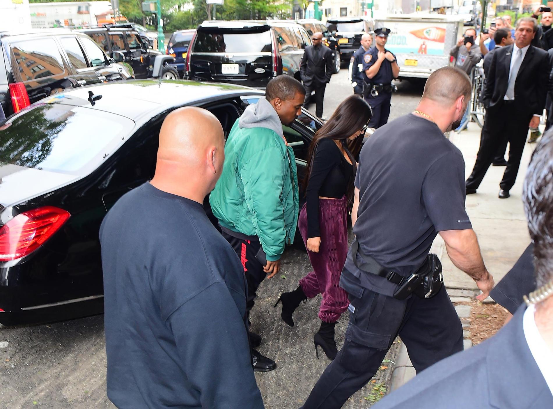 Kim Kardashian och Kanye West omgiven av säkerhetspersonal.