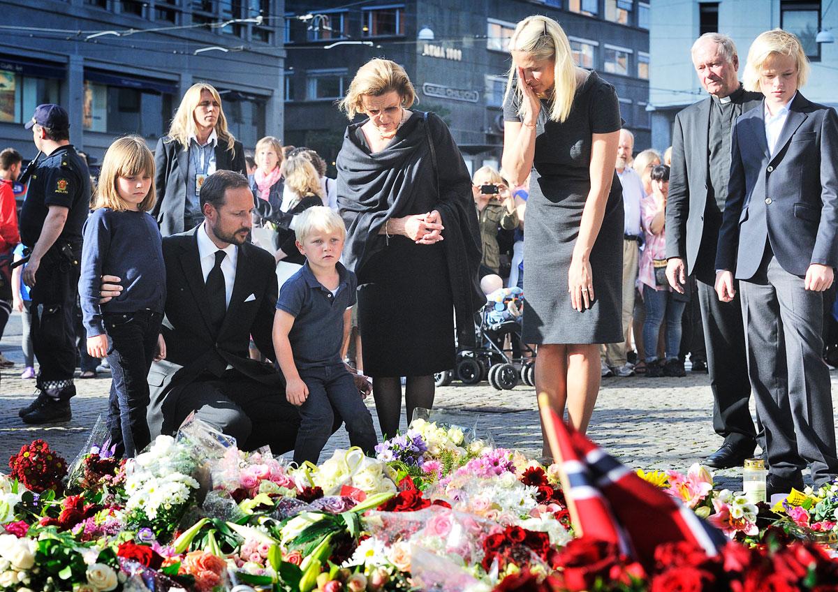 Kronprins Haakon med familj sörjer vid en minnesplats i Oslo.