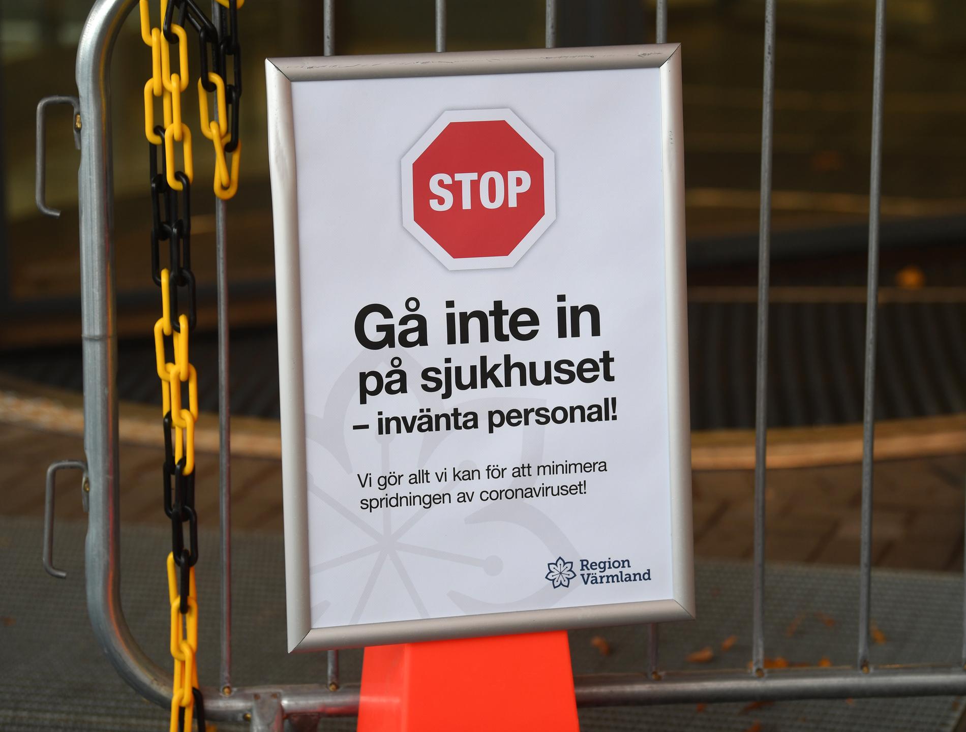 En skylt varnar för corona och uppmanar patienter att inte gå in i sjukhuset vid enten till Centralsjukhuset i Karlstad i Värmland.
