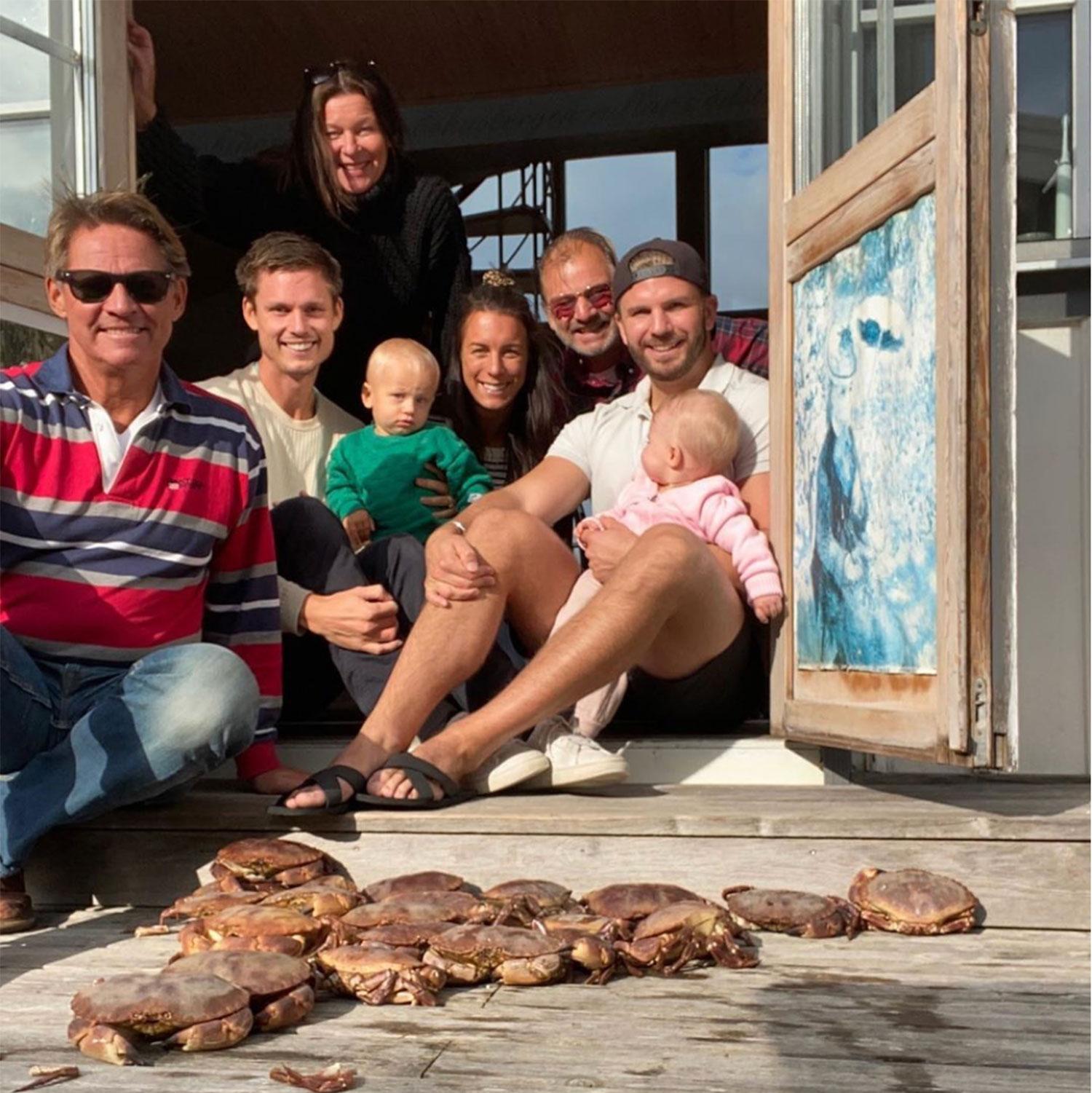 Lotta Engberg tillsammans med Mikael Sandström och hans son Marcus, dennes fru Sandra med lille Bernhard och Sandströms bror Jeppe och hans son Martin med lilla Livia i knät. Och några av de 22 fångade krabborna.