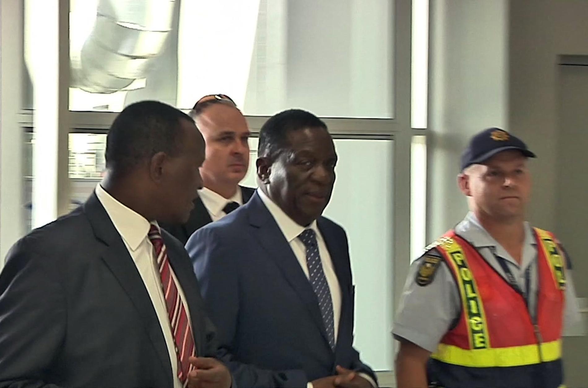 Zimbabwes snart tillträdande ledare Emmerson Mnangagwa (i mitten) bordar planet i Sydafrika inför resan till Zimbabwe.