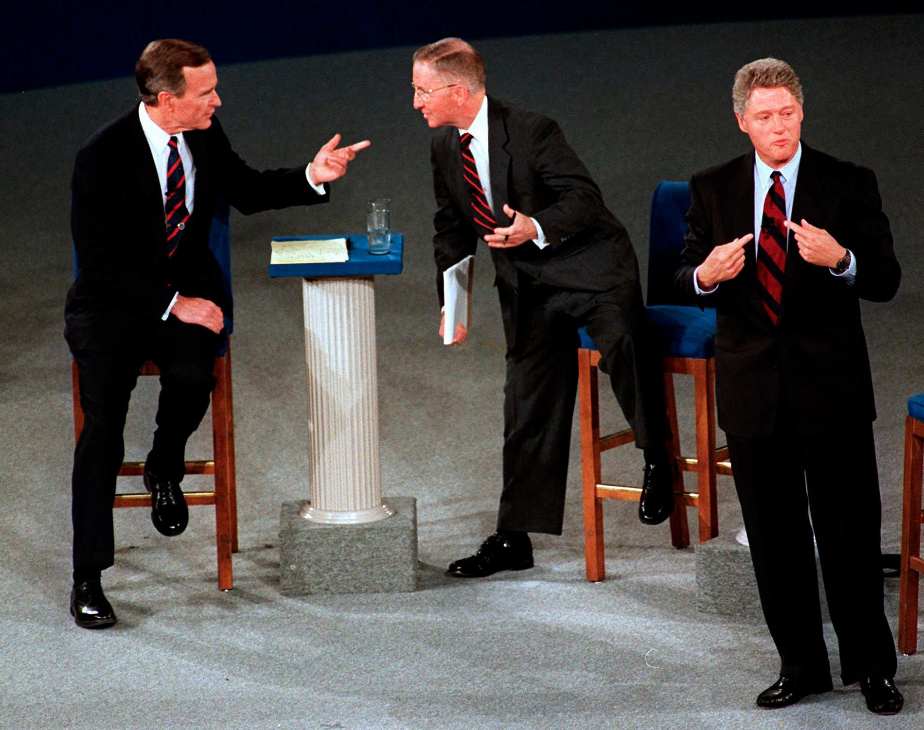 n this Oct. 15, 1992, file photo, President George H.W. Bush, left, talks with independent candidate Ross Perot as Democratic candidate Bill Clinton stands aside at the end of their second presidential debate in Richmond, Va.