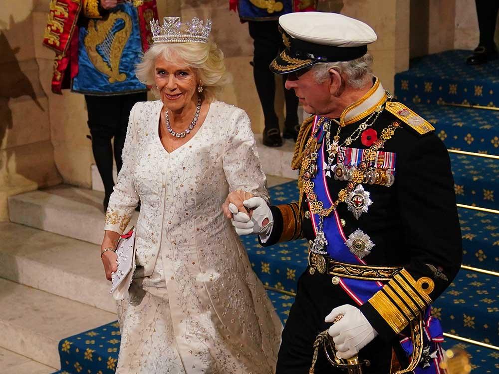 Kung Charles och drottning Camilla lämnar parlamentet efter kungens tal. Drottningen bär sin kröningsklänning. 