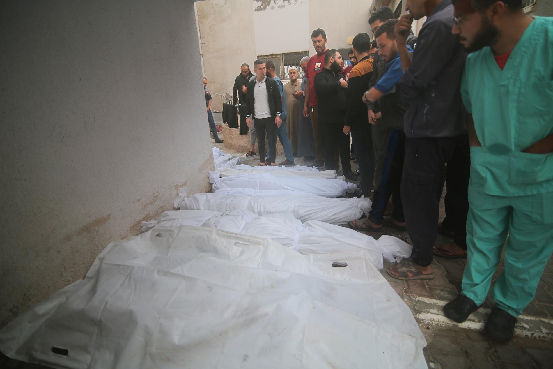 Palestinier med sina släktingars kroppar, som dödats i israeliska bombräder 23 oktober.