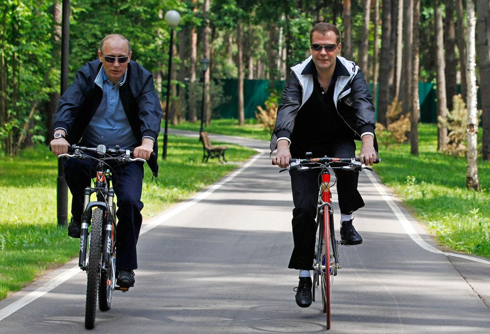 Ute och cyklar? Putin och premiärminister Dimitrij Medvedev tar en tur.