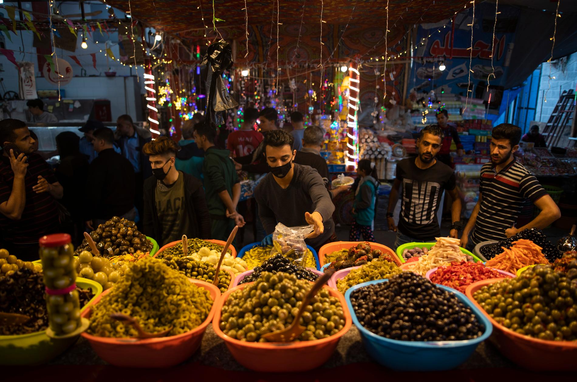 En försäljare av inlagda grönsaker bär munskydd på marknaden Zawiya i Gaza City. Bilden är från den 28 april.