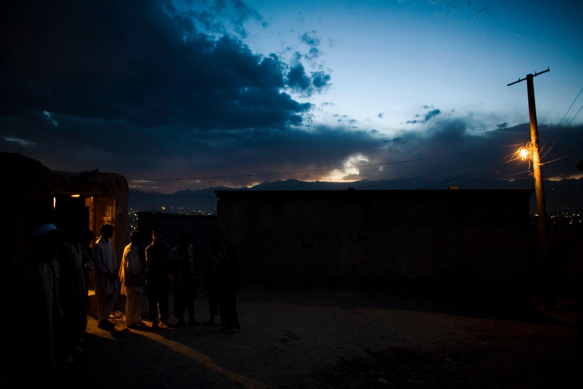 En majoritet av afghanerna är inte anslutna till något elnät. På bilden står några män utanför ett hushåll i Kabulområdet som förlitar sig på en dieselgenerator för att hålla ljusen tända. Arkivfoto.