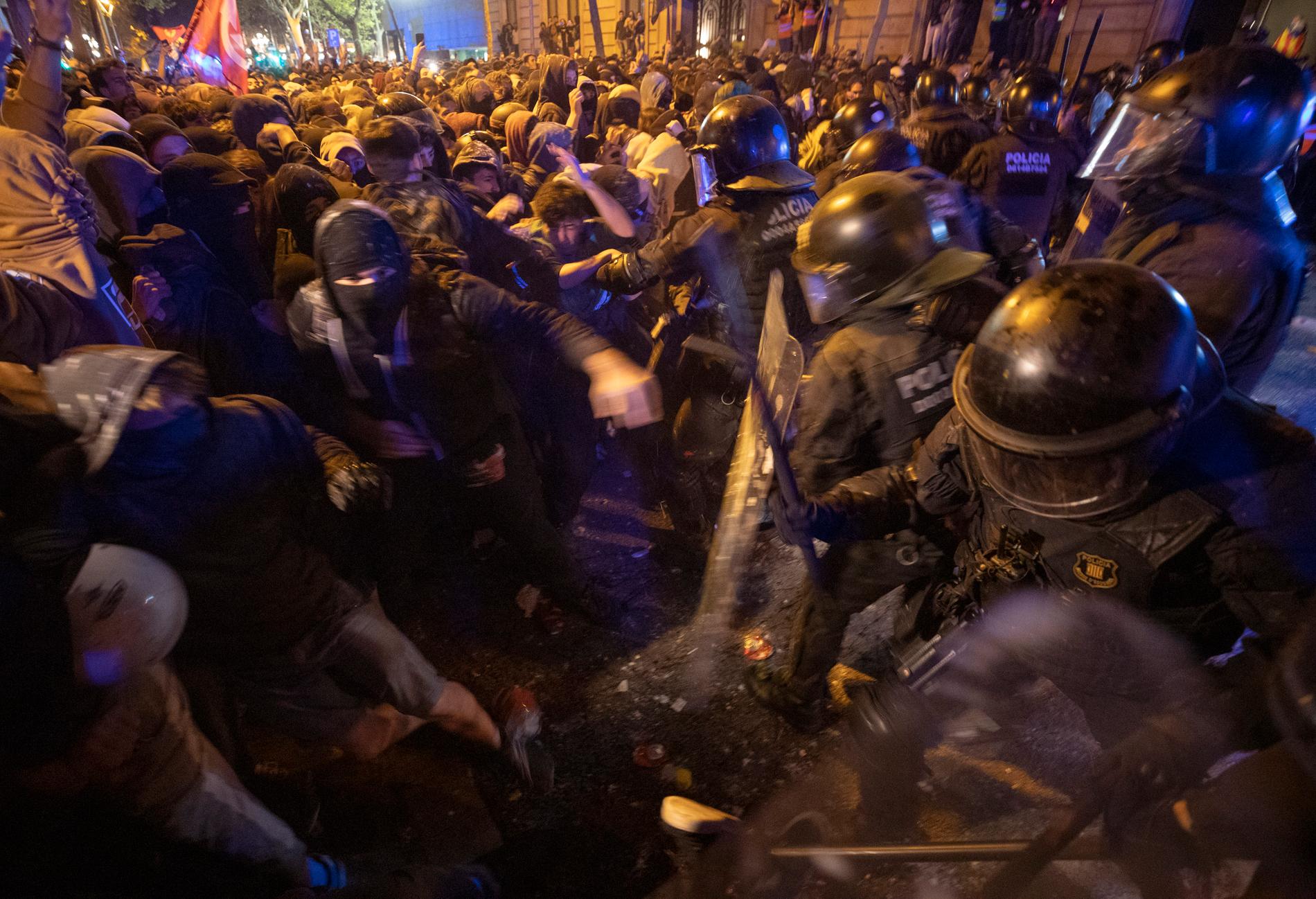 Demonstranter drabbar samman med kravallutrustad polis i Barcelona under tisdagskvällen.