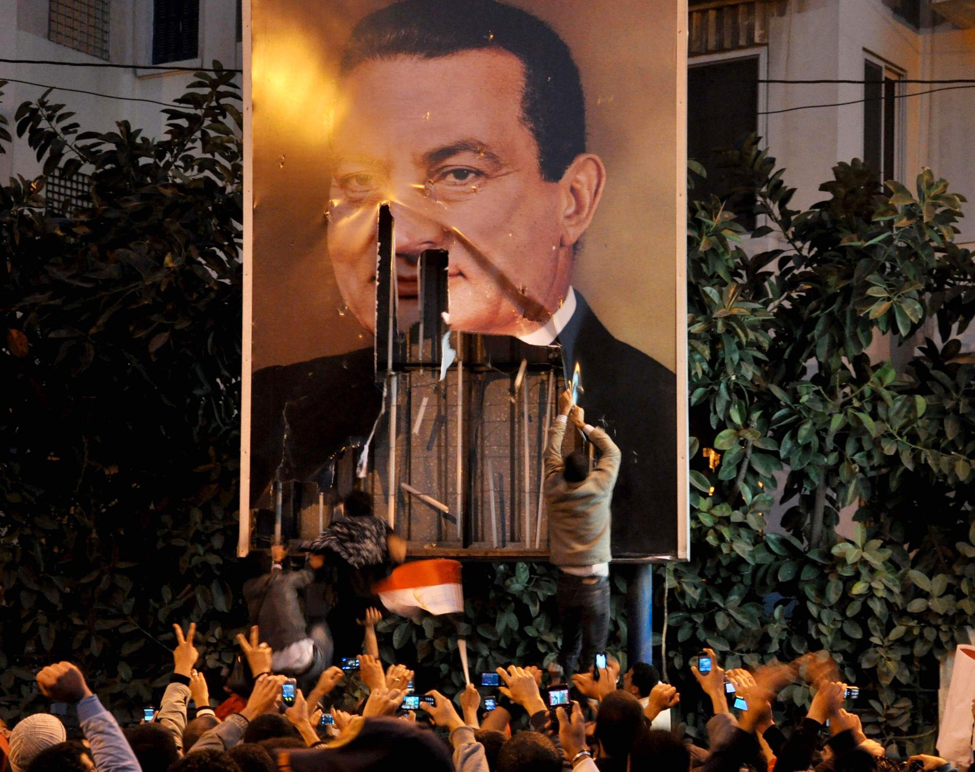 Demonstranter river ned en stor affisch som föreställer Hosni Mubarak i Alexandria, i januari 2011. Arkivbild.