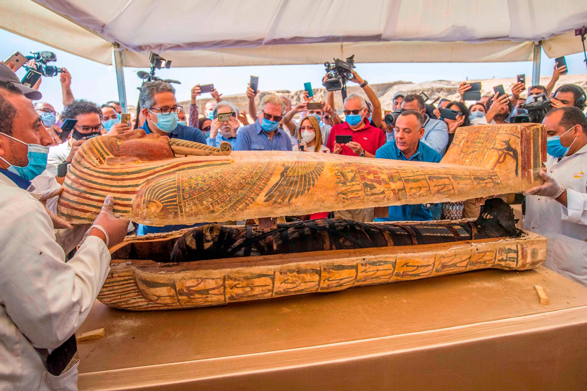 Egyptens turistminister Khaled al-Anani (till vänster) gläntar på locket till en sarkofag.