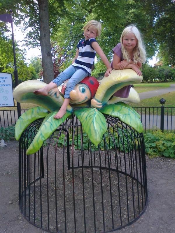 Systrarna Lovis och Alva sitter på en nyckelpiga på lekplatsen i Stadsträdgården i Lidköping!
