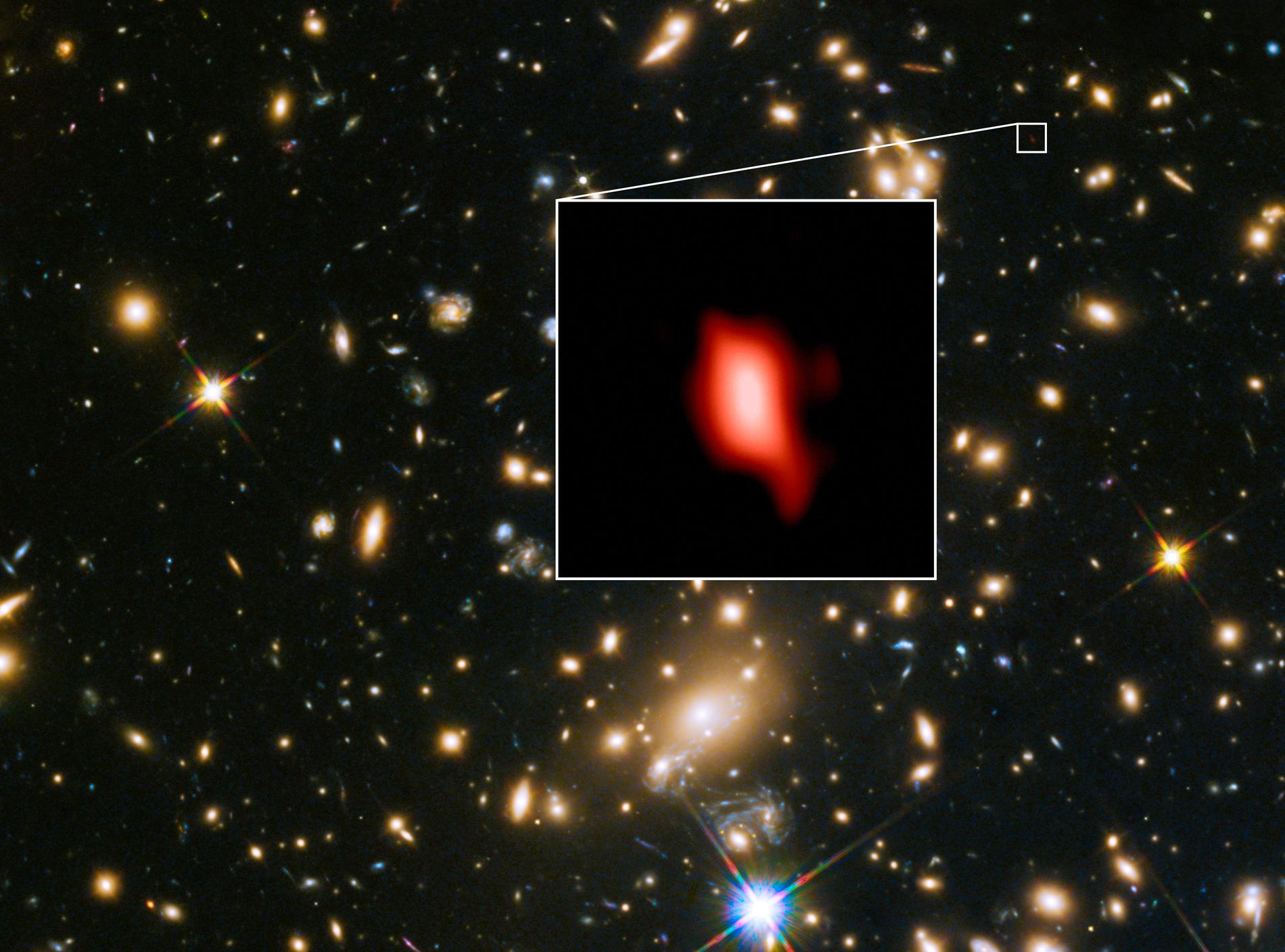 På bilden syns den avlägsna galaxhopen som forskarna studerat med teleskopen Alma och VLT. I galaxen MACS1149-JD1 (infälld på bilden) har forskarna kunnat se bevis för extremt tidiga stjärnor.