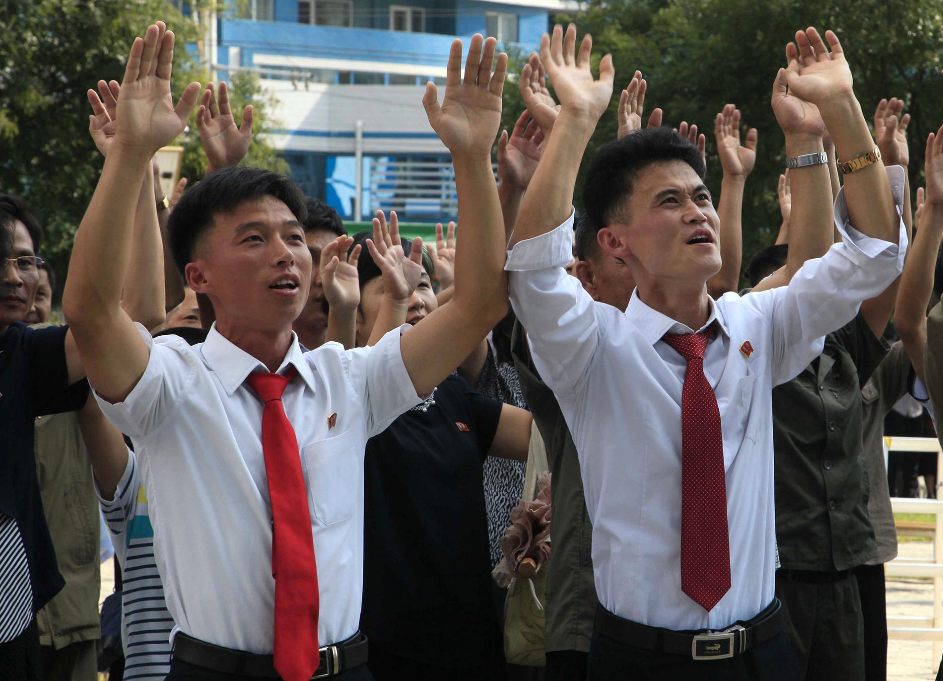 Människor på en gata i Nordkoreas huvudstad Pyongyang reagerar på nyheten om landets provsprängning.